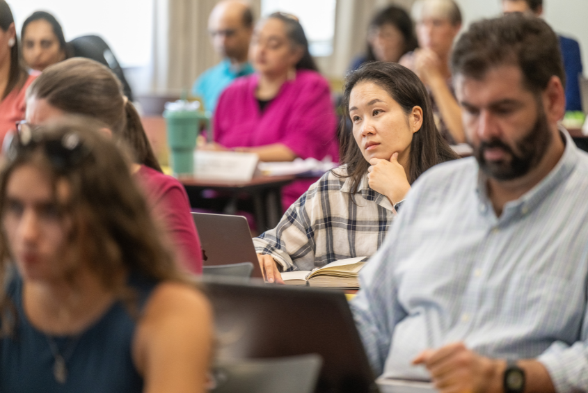 People attending a meeting and listening to a presentation.