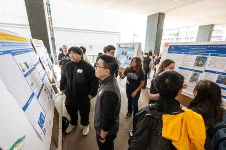 Students reading a poster at Student Research Day.